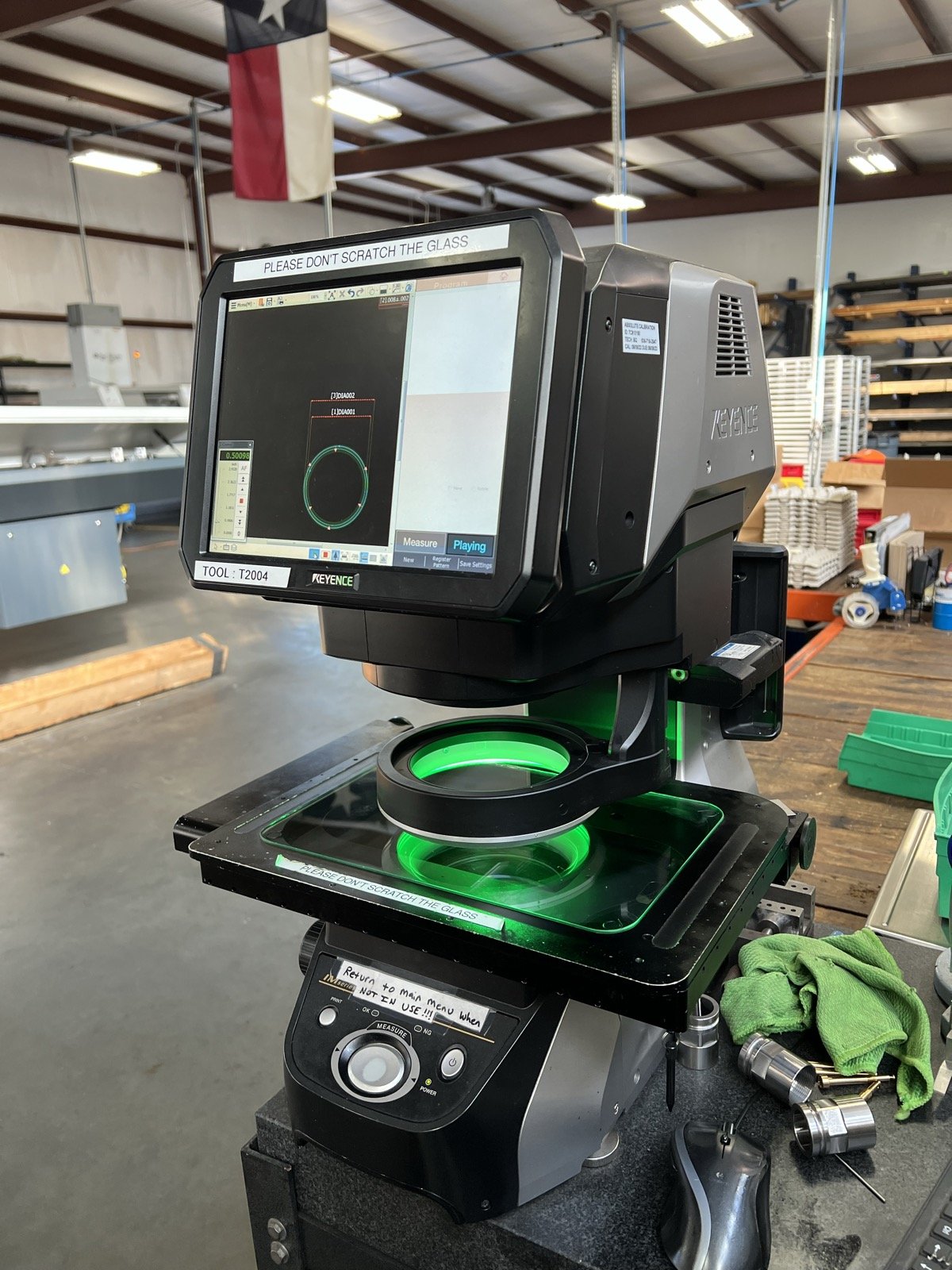 TXSwiss Keyence IM-Series optical comparator measuring a precision-machined ring under green LED transmitted light at the Conroe, Texas quality control lab