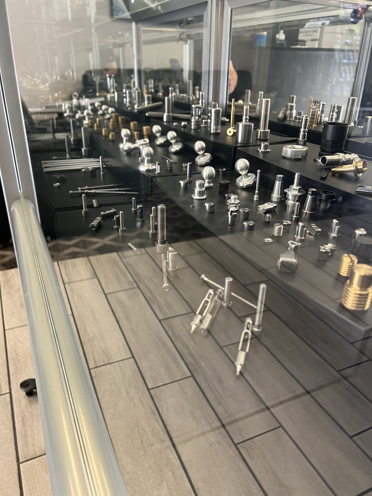 Collection of TXSwiss-machined precision components in stainless steel, brass, and aluminum on display